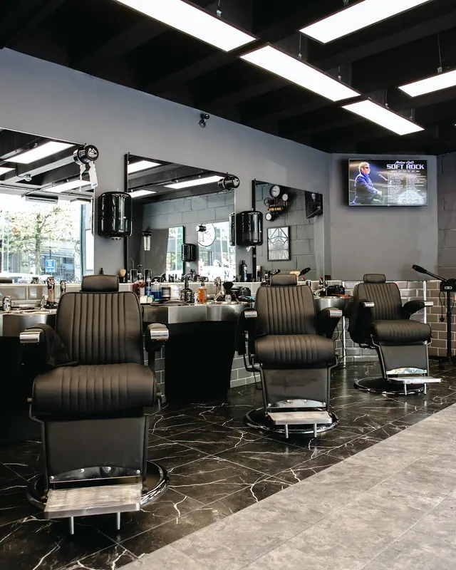 Three barber chairs along the mirrors