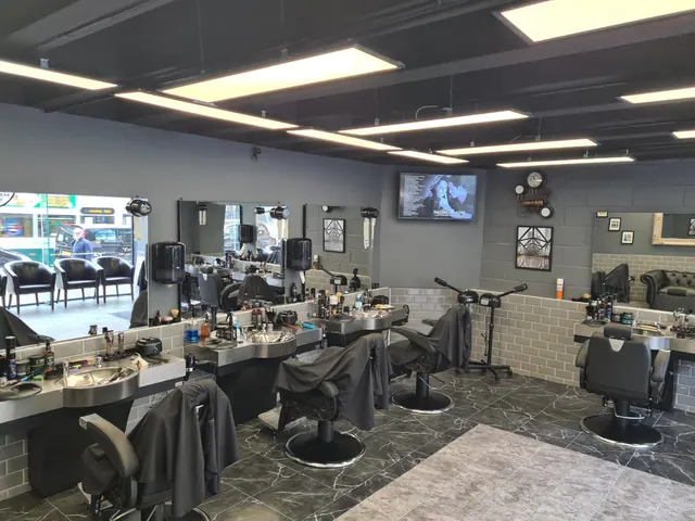 The row of barber stations and mirrors under the ceiling lights